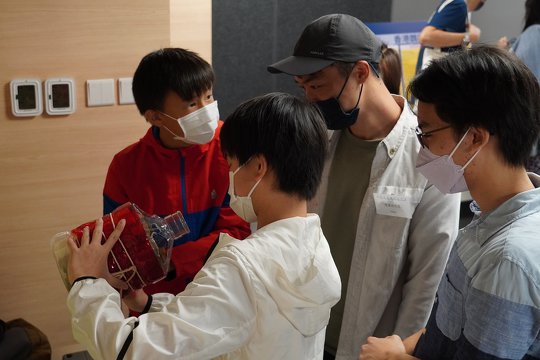 There is a free-flow Q&A session after the ceremony. The student is introducing his insect hotel to local wildlife photographer, Mr. Fung Hon Shing.